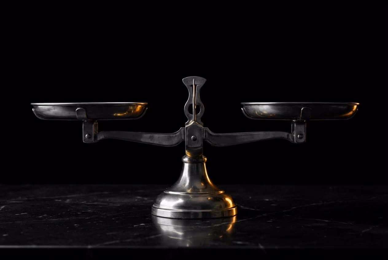 A classical gold weighing scale balanced perfectly on a dark marble table representing a balanced lifestyle system