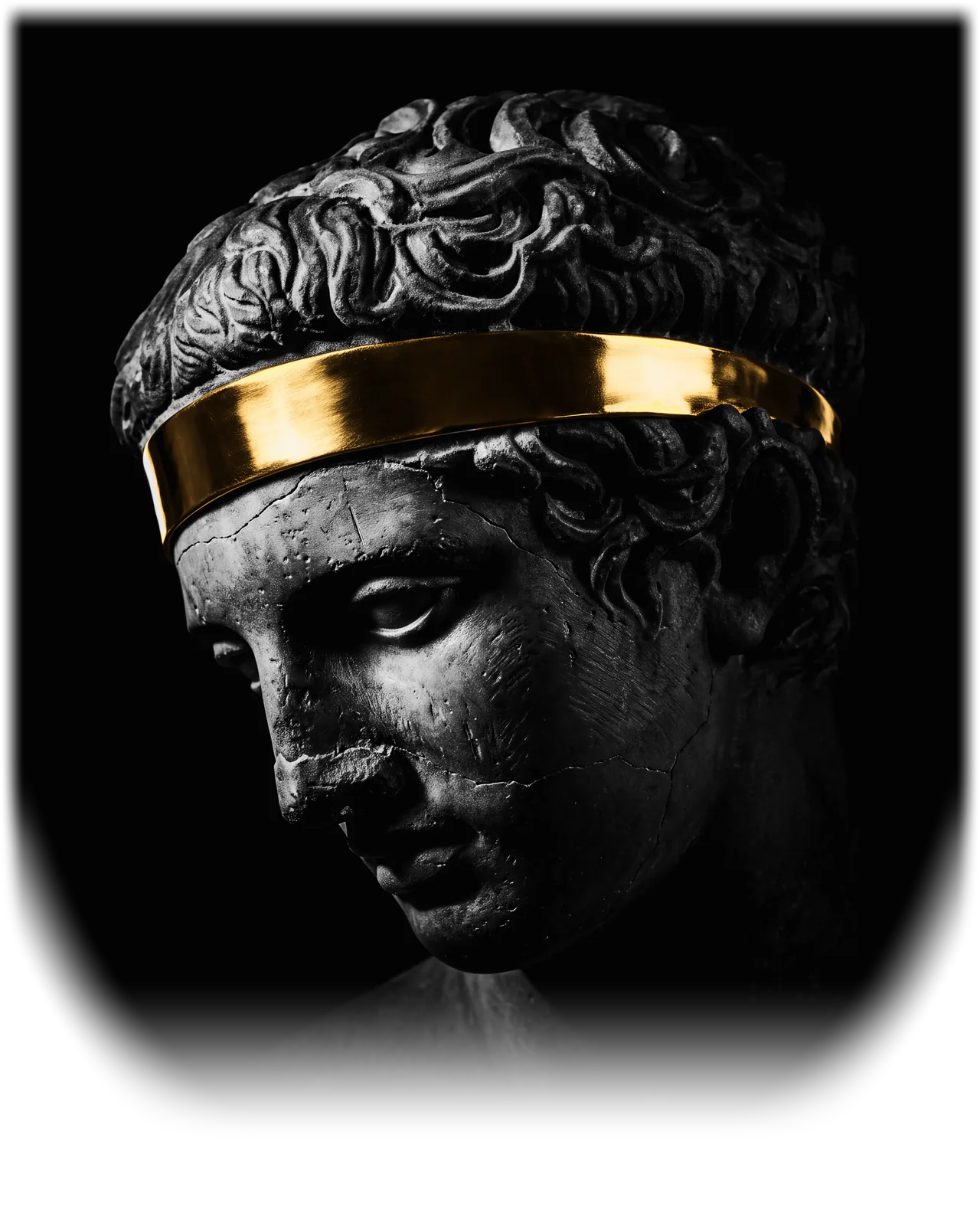 The head of a dark stone statue of a young athlete, bowed and turned to the left, a band of polished gold bound around his hair.